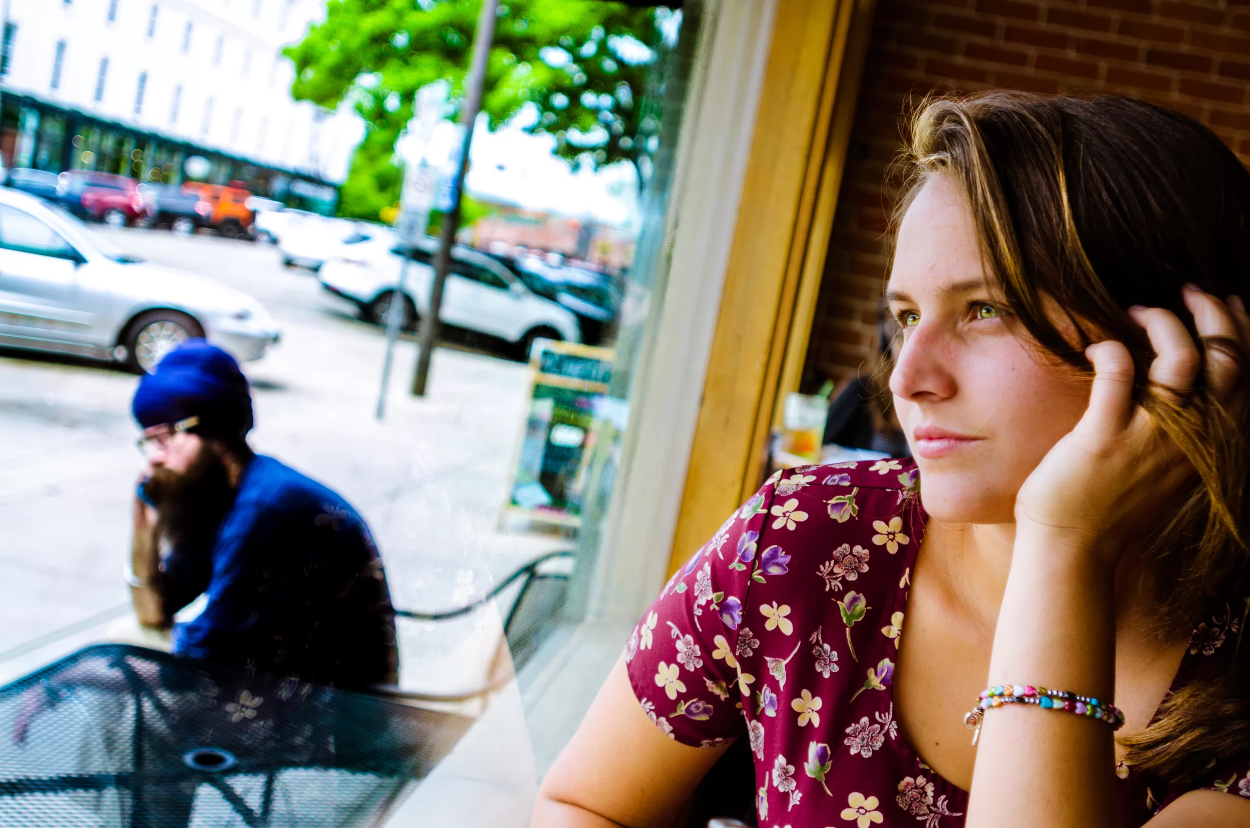 Woman looking out the window of a coffee shop symbollically contemplating how to regain focus and motivation.